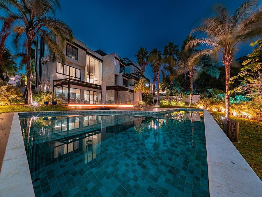 Casa de condomínio à venda em Alphaville com piscina iluminada ao anoitecer